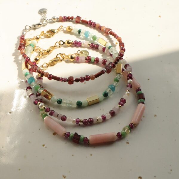 Kralenarmbanden met edelstenen in verschillende kleuren.