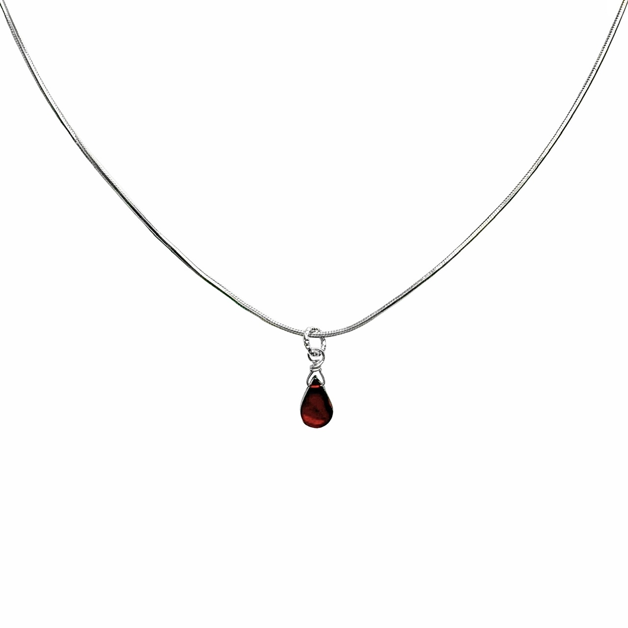 Een “slangen” collier van sterling zilver met een druppelvormige hanger van rode granaat.