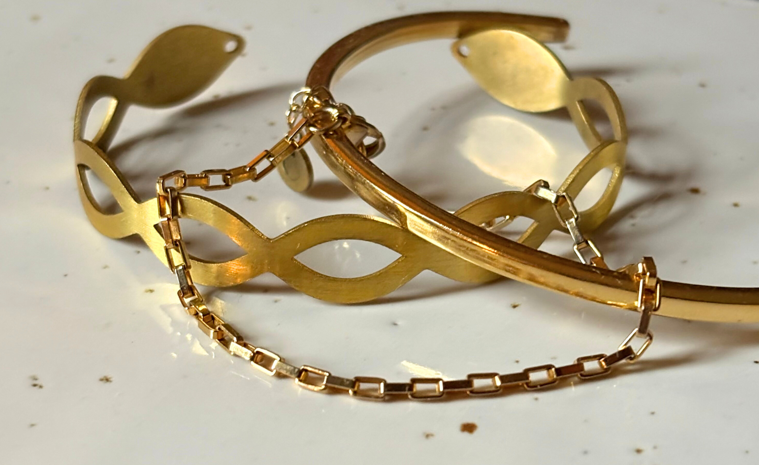 Een stapel met gouden geometrische armbanden