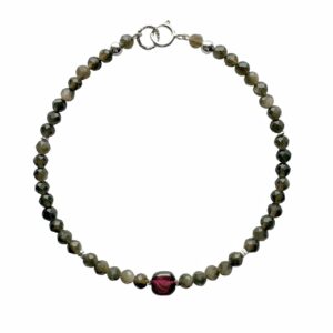 Kralenarmband met een kussentje van rood granaat en kralen van obsidiaan.