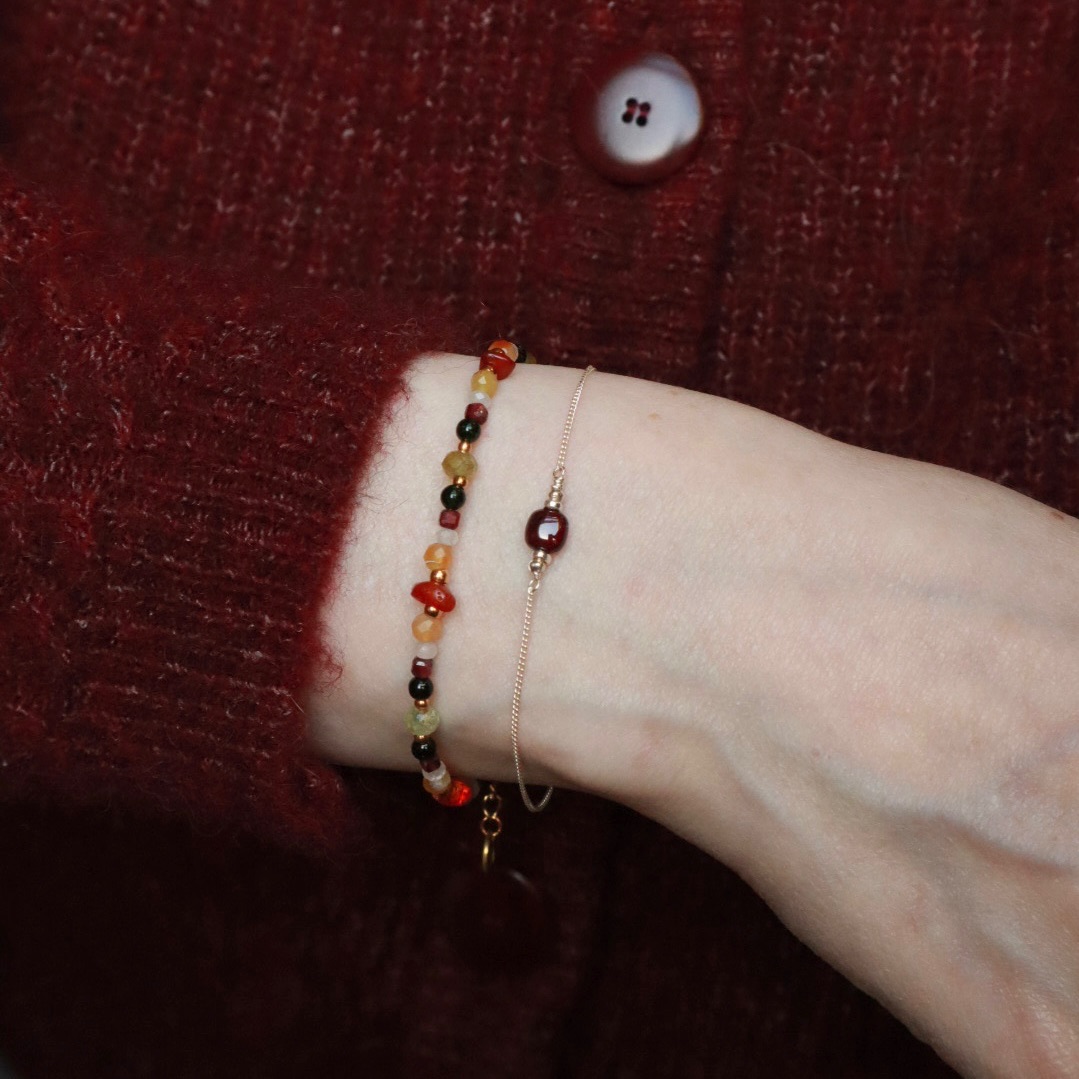Armbandenset met een gemixte kralenarmband van edelstenen. En een verfijnde schakelarmband met een kussentje van rode granaat.